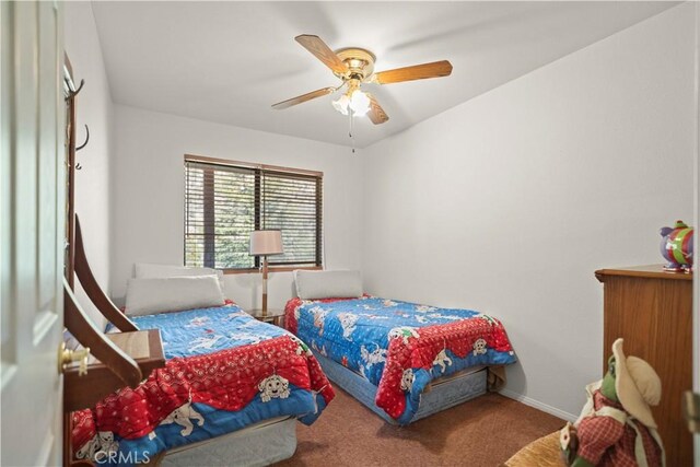 carpeted bedroom featuring baseboards and a ceiling fan
