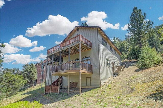 rear view of house featuring stairs and a deck