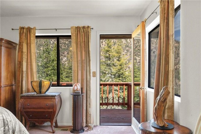doorway with carpet floors and baseboards