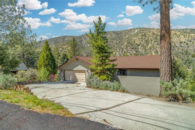view of front of property with an attached garage, a mountain view, and concrete driveway