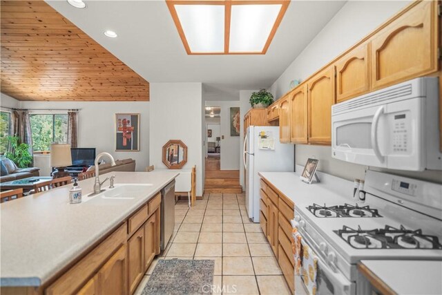 kitchen featuring white appliances, open floor plan, recessed lighting, light countertops, and a sink