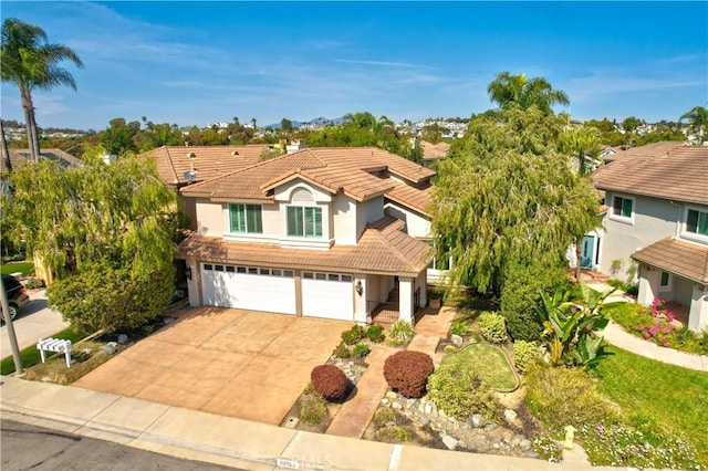 traditional-style home with a tiled roof, stucco siding, driveway, and a garage