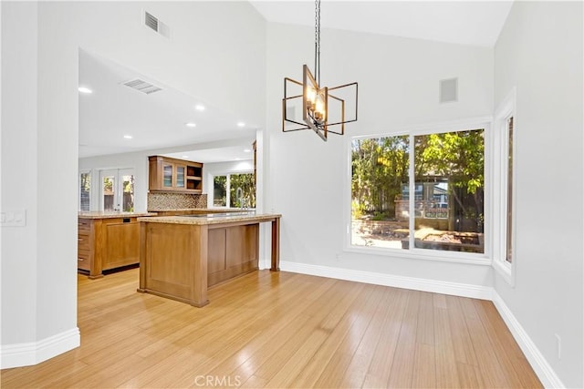 interior space featuring a notable chandelier, light wood finished floors, and visible vents