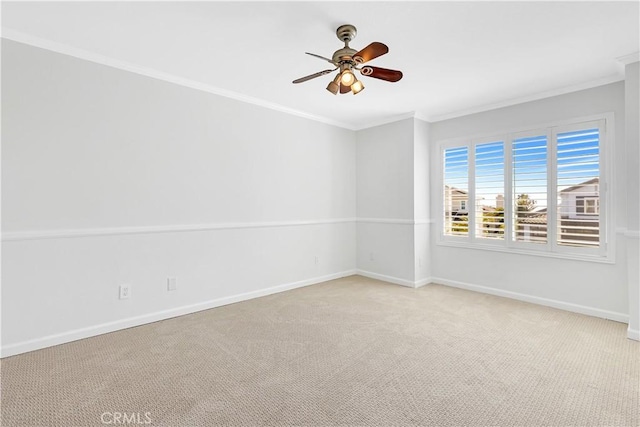 unfurnished room featuring crown molding, a ceiling fan, baseboards, and light carpet
