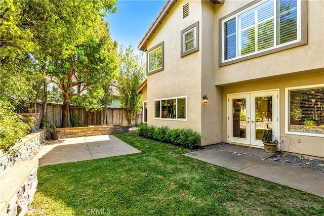 view of yard featuring french doors, a fenced backyard, and a patio area