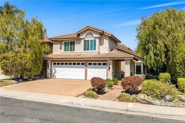 traditional home with an attached garage, stucco siding, driveway, and a tile roof