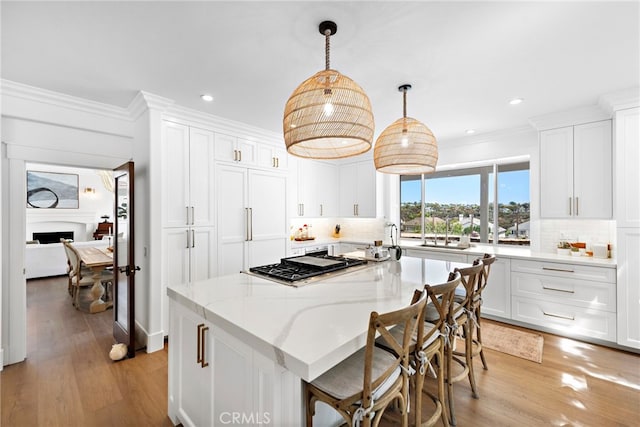 14 Belaire, Laguna Niguel, CA 92677 - kitchen with light wood-type flooring, a sink, white cabinets, and ornamental molding