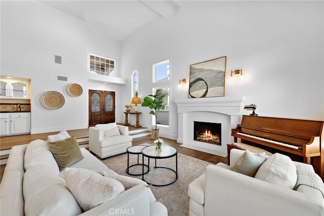 14 Belaire, Laguna Niguel, CA 92677 - living room with high vaulted ceiling, a fireplace with flush hearth, wood finished floors, beamed ceiling, and visible vents