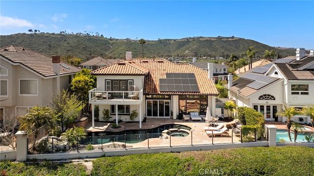 14 Belaire, Laguna Niguel, CA 92677 - back of house with a balcony, stucco siding, a tiled roof, a mountain view, and solar panels