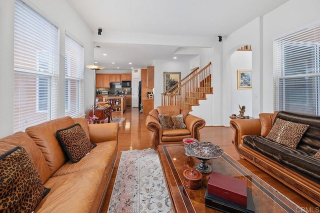 living area with light wood finished floors and stairway