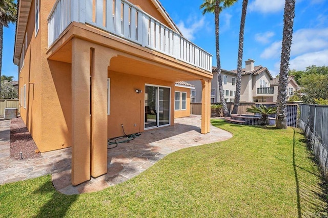 rear view of house with central AC, a fenced backyard, a yard, a patio, and stucco siding