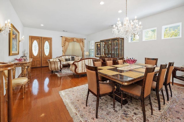 dining room featuring a healthy amount of sunlight, recessed lighting, wood finished floors, and a chandelier