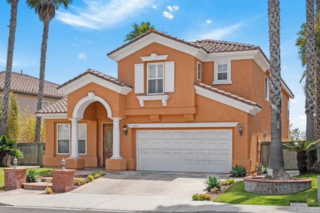 mediterranean / spanish-style home featuring a garage, fence, a tiled roof, and concrete driveway