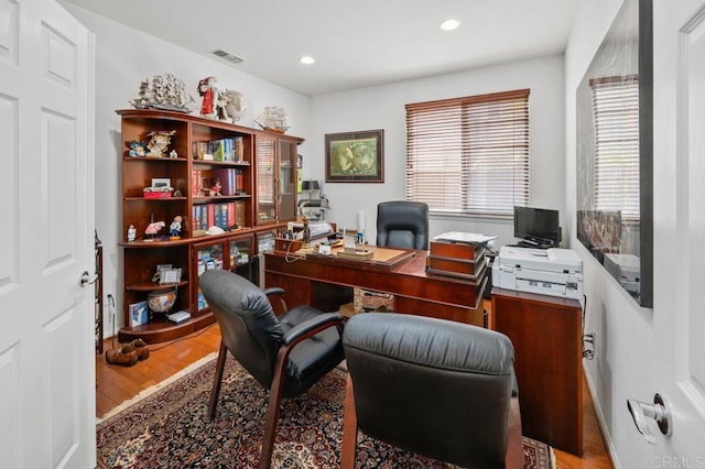 home office with recessed lighting, wood finished floors, and visible vents