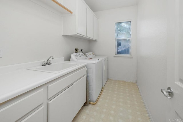 washroom featuring cabinet space, independent washer and dryer, and a sink