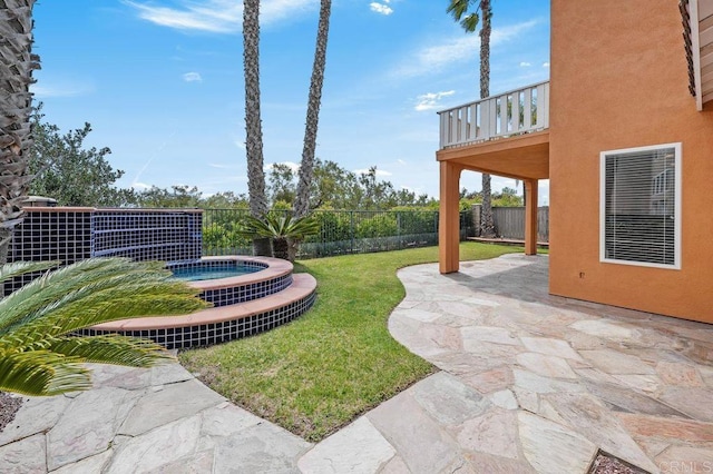 view of yard with fence, an in ground hot tub, a patio area, and a balcony