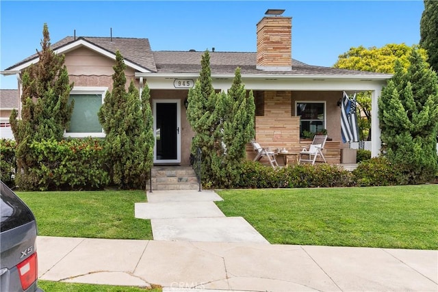 945 10th St, Huntington Beach, CA 92648 - view of front facade featuring a shingled roof, a chimney, and a front yard