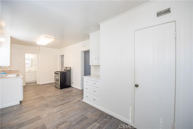 945 10th St, Huntington Beach, CA 92648 - kitchen with visible vents, stainless steel gas stove, light countertops, a sink, and light wood finished floors