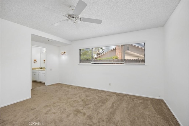 unfurnished bedroom with a textured ceiling, light colored carpet, and baseboards