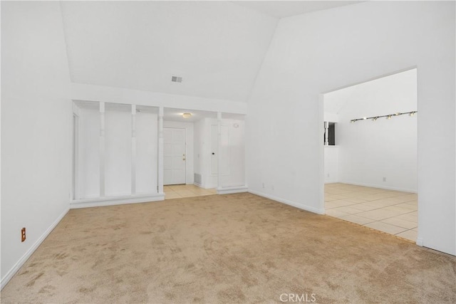 spare room with tile patterned flooring, carpet floors, high vaulted ceiling, baseboards, and visible vents