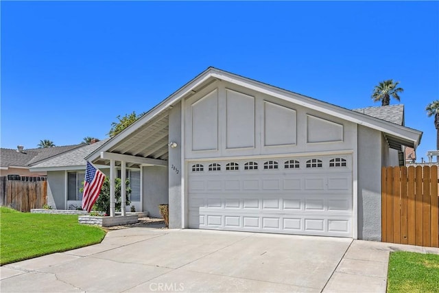 view of front of home with fence, a garage, stucco siding, a front yard, and driveway