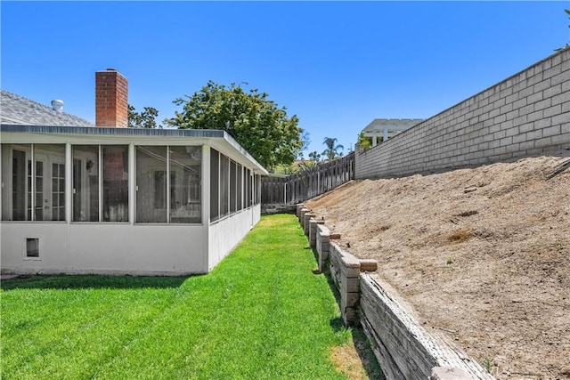 view of yard featuring a fenced backyard and a sunroom