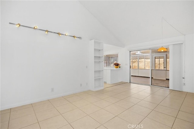 empty room with tile patterned flooring, baseboards, and high vaulted ceiling