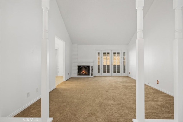 unfurnished living room featuring baseboards, vaulted ceiling, carpet, and a fireplace