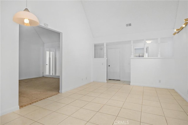 spare room with baseboards, tile patterned flooring, and high vaulted ceiling