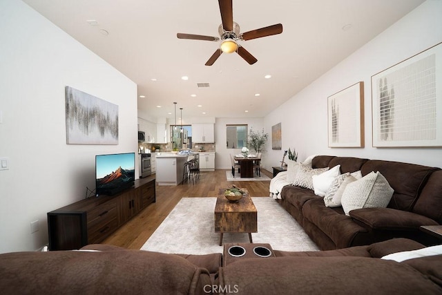 living area with visible vents, a ceiling fan, light wood-style flooring, and recessed lighting