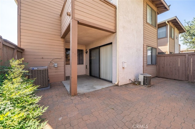 back of house featuring a patio, central AC unit, fence, and stucco siding