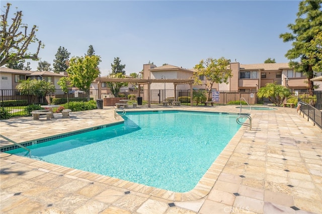 pool featuring a residential view, fence, a patio, and a community hot tub