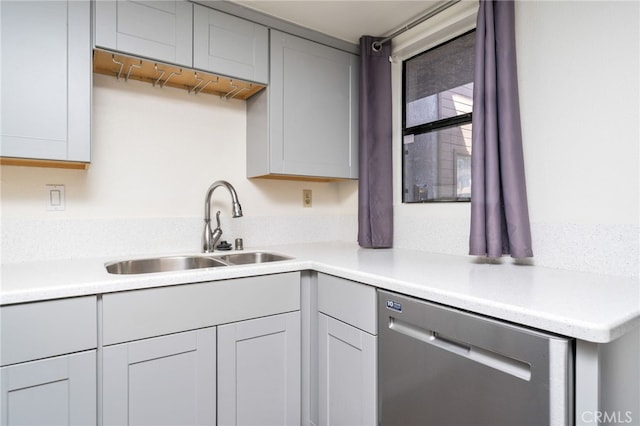 kitchen featuring light countertops, a sink, and dishwasher