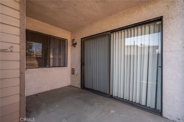 property entrance featuring a patio and stucco siding