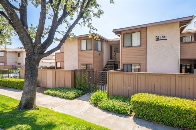 1303 Massachusetts Ave Unit 101, Riverside, CA 92507 - view of front of house featuring a fenced front yard, stairs, and stucco siding