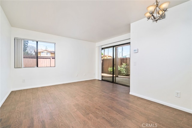 1303 Massachusetts Ave Unit 101, Riverside, CA 92507 - empty room with dark wood-type flooring, a chandelier, and baseboards