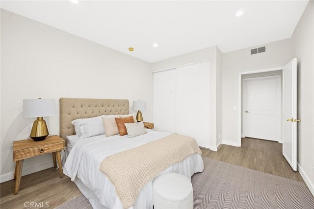 1310 N Detroit St Unit 405, Los Angeles, CA 90046 - bedroom featuring baseboards, visible vents, wood finished floors, and a closet