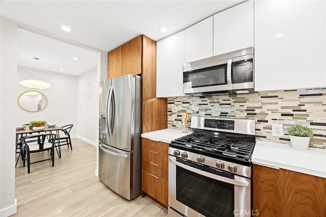 1310 N Detroit St Unit 405, Los Angeles, CA 90046 - kitchen featuring light countertops, stainless steel appliances, brown cabinetry, and light wood-style floors
