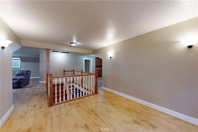 bonus room with baseboards and wood finished floors