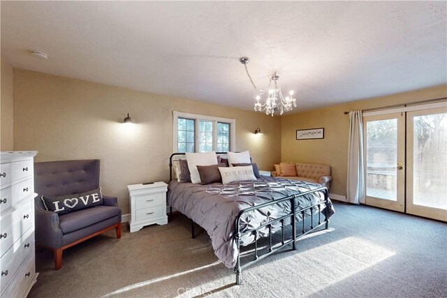 carpeted bedroom featuring an inviting chandelier, baseboards, and access to exterior