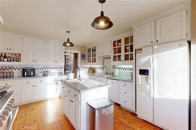 1473 Willow Rd, Nipomo, CA 93444 - kitchen featuring white appliances, decorative backsplash, light wood-type flooring, an island with sink, and glass insert cabinets