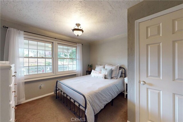 carpeted bedroom with baseboards and a textured ceiling