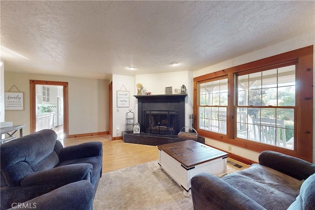 1473 Willow Rd, Nipomo, CA 93444 - living area with a textured ceiling, a tile fireplace, and light wood-style floors