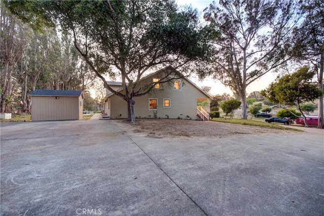 view of side of home with a storage shed and an outdoor structure
