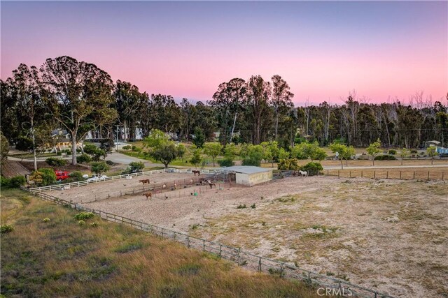 yard at dusk with a rural view and fence