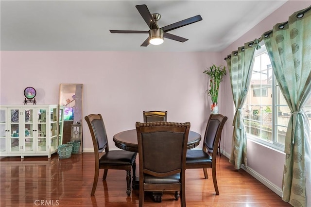 dining area featuring wood finished floors, baseboards, and ceiling fan