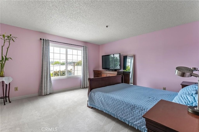 bedroom featuring a textured ceiling, light carpet, and baseboards