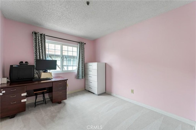 office featuring a textured ceiling, light carpet, and baseboards