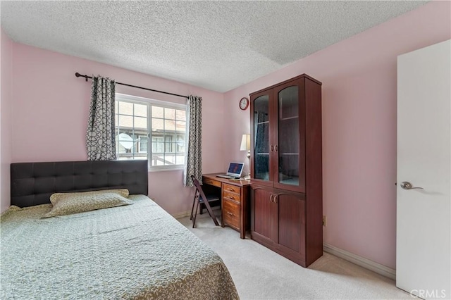bedroom with a textured ceiling, baseboards, and light colored carpet