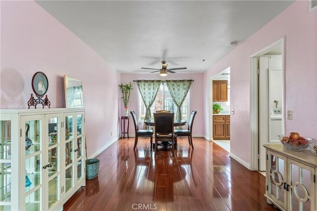 dining room with baseboards, a ceiling fan, visible vents, and dark wood-type flooring